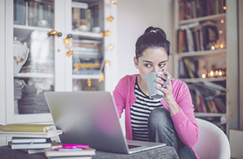 girl on laptop drinking out of a mug