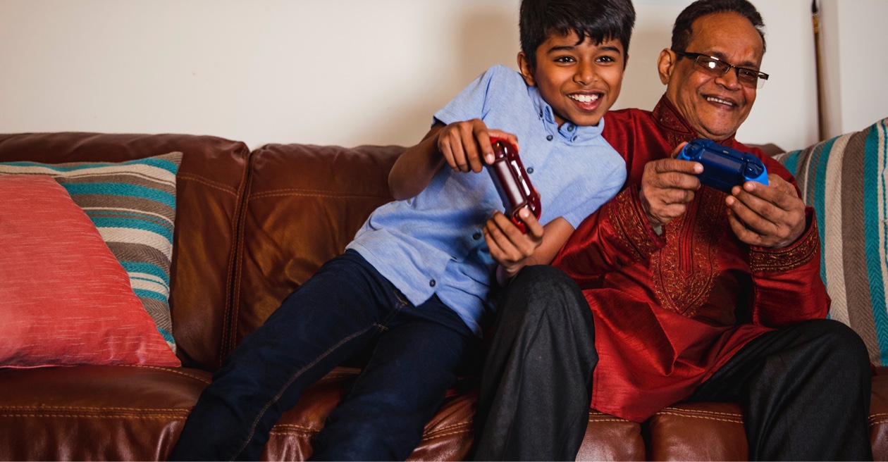 father and son sitting on couch playing video game