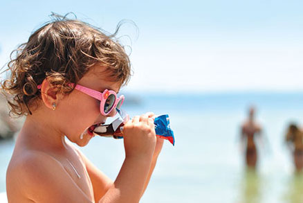 Child eating ice cream at the beach